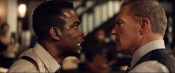 Movie still from “Spiral” (2021), directed by Darren Lynn Bousman – Two men face each other in an open room; Close Up shot, Over the shoulder angle