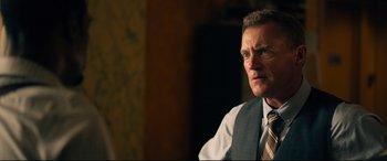 Movie still from “Spiral” (2021), directed by Darren Lynn Bousman – A person wearing a suit and tie; Close Up shot, Over the shoulder angle