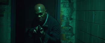 Movie still from “Spiral” (2021), directed by Darren Lynn Bousman – A man in a black jacket is holding a cane; Medium shot, Low angle