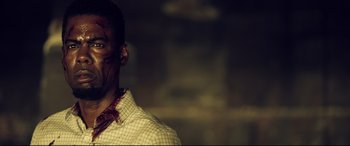 Movie still from “Spiral” (2021), directed by Darren Lynn Bousman – A person wearing a shirt with blood all over his face; Close Up shot, Over the shoulder angle