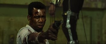 Movie still from “Spiral” (2021), directed by Darren Lynn Bousman – A man holding a gun with blood on his face; Close Up shot, Over the shoulder angle