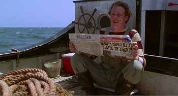 Movie still from “Splash” (1983), directed by Ron Howard – A man sitting on a boat reading a newspaper; Medium shot, Low angle