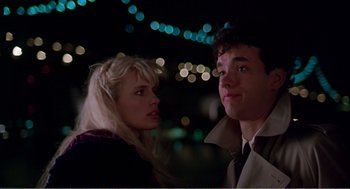 Movie still from “Splash” (1983), directed by Ron Howard – A man and a woman standing next to each other in front of lights; Close Up shot, Over the shoulder angle