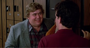 Movie still from “Splash” (1983), directed by Ron Howard – Two men talking to each other in front of a mirror; Medium shot, Over the shoulder angle