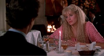 Movie still from “Splash” (1983), directed by Ron Howard – A woman sitting at a dinner table with a candle; Medium shot, Over the shoulder angle