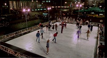 Movie still from “Splash” (1983), directed by Ron Howard – People skating on the ice rink at night time; Extreme Wide shot, High angle