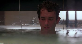 Movie still from “Splash” (1983), directed by Ron Howard – A young man in a pool of water looking down; Close Up shot, Low angle