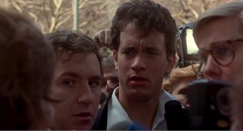 Movie still from “Splash” (1983), directed by Ron Howard – Two young men standing next to each other in a crowd of people; Close Up shot, Over the shoulder angle