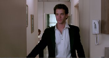 Movie still from “Splash” (1983), directed by Ron Howard – A man in a suit and white shirt in a hallway; Medium shot, Low angle