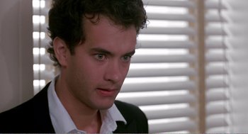 Movie still from “Splash” (1983), directed by Ron Howard – A young man with green eyes stares into the distance; Close Up shot, Over the shoulder angle