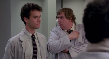 Movie still from “Splash” (1983), directed by Ron Howard – Two men in white lab coats looking at each other in a room; Close Up shot, Low angle