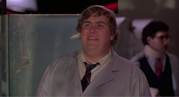 Movie still from “Splash” (1983), directed by Ron Howard – A man wearing a suit and tie smiling for the camera; Close Up shot, Low angle