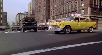 Movie still from “Splash” (1983), directed by Ron Howard – An old yellow truck is driving down the street; Wide shot, Low angle