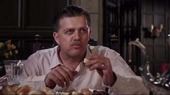 Movie still from “Splendor in the Grass” (1961), directed by Elia Kazan – A man sitting at a dinner table eating food; Close Up shot, Low angle