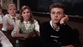 Movie still from “Splendor in the Grass” (1961), directed by Elia Kazan – A man and a woman sitting in front of a chalkboard; Medium shot, Over the shoulder angle