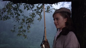 Movie still from “Splendor in the Grass” (1961), directed by Elia Kazan – A young woman holding an umbrella while standing under a tree; Close Up shot, Low angle