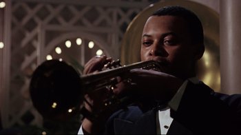 Movie still from “Splendor in the Grass” (1961), directed by Elia Kazan – A man in a suit and tie playing a trumpet; Close Up shot, Low angle