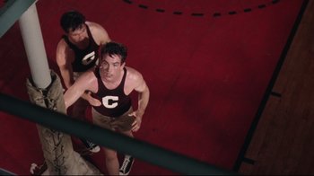 Movie still from “Splendor in the Grass” (1961), directed by Elia Kazan – A couple of men standing next to each other on a court; Medium shot, Overhead angle