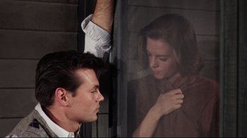 Movie still from “Splendor in the Grass” (1961), directed by Elia Kazan – A man and a woman looking at each other through a window; Medium shot, High angle