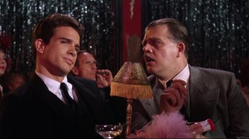 Movie still from “Splendor in the Grass” (1961), directed by Elia Kazan – Two men are sitting at a table and one of them is talking; Medium shot, Over the shoulder angle