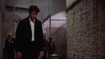 Movie still from “Splendor in the Grass” (1961), directed by Elia Kazan – A man in a suit and tie holding a cell phone; Medium shot, Over the shoulder angle