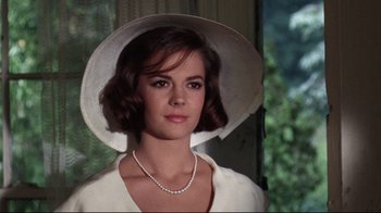 Movie still from “Splendor in the Grass” (1961), directed by Elia Kazan – A woman in a white dress and a white hat; Close Up shot, Low angle