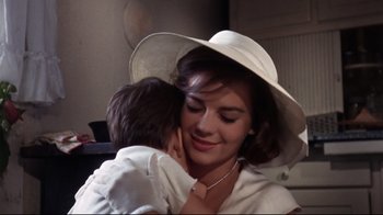 Movie still from “Splendor in the Grass” (1961), directed by Elia Kazan – A woman in a white hat is holding a child; Close Up shot, Low angle