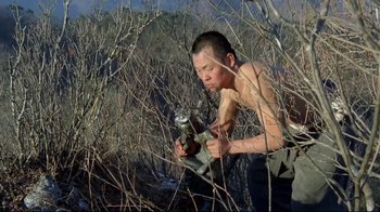 Movie still from “Spring, Summer, Fall, Winter... and Spring” (2003), directed by Kim Ki-duk – A man in the woods holding a gun; Medium shot, Low angle