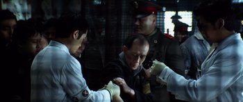 Movie still from “Spy Game” (2001), directed by Tony Scott – A group of men in uniform are standing together; Medium shot, Over the shoulder angle