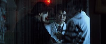 Movie still from “Spy Game” (2001), directed by Tony Scott – A group of people standing next to each other in a room; Close Up shot, Over the shoulder angle