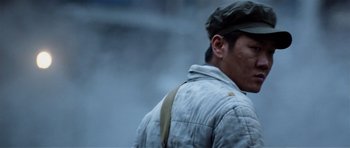 Movie still from “Spy Game” (2001), directed by Tony Scott – A man wearing a hat and a jacket walking down a street; Close Up shot, Low angle