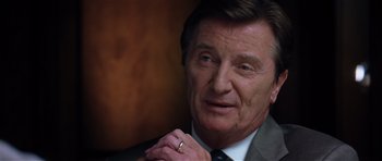 Movie still from “Spy Game” (2001), directed by Tony Scott – An older man wearing a suit and tie with a ring; Close Up shot, Over the shoulder angle