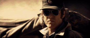 Movie still from “Spy Game” (2001), directed by Tony Scott – An older man wearing a hat and sunglasses; Close Up shot, Low angle