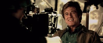 Movie still from “Spy Game” (2001), directed by Tony Scott – A person sitting in front of a camera; Close Up shot, Over the shoulder angle