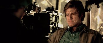 Movie still from “Spy Game” (2001), directed by Tony Scott – A person sitting in front of a camera; Close Up shot, Low angle