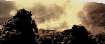 Movie still from “Spy Game” (2001), directed by Tony Scott – Smoke billows from a fire in a field; Extreme Wide shot, Low angle