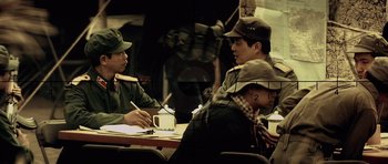 Movie still from “Spy Game” (2001), directed by Tony Scott – A group of people sitting at a table; Medium shot, Over the shoulder angle