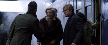 Movie still from “Spy Game” (2001), directed by Tony Scott – A man and a woman are talking to a man; Medium shot, Over the shoulder angle