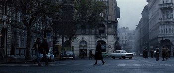 Movie still from “Spy Game” (2001), directed by Tony Scott – A person is walking down the street near a building; Extreme Wide shot, High angle