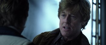 Movie still from “Spy Game” (2001), directed by Tony Scott – A person wearing a brown jacket; Close Up shot, Over the shoulder angle