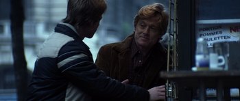 Movie still from “Spy Game” (2001), directed by Tony Scott – Two men standing next to each other on a street; Medium shot, Over the shoulder angle