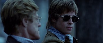 Movie still from “Spy Game” (2001), directed by Tony Scott – A man wearing sunglasses and a leather jacket; Close Up shot, Over the shoulder angle