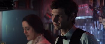 Movie still from “Spy Game” (2001), directed by Tony Scott – A man in a suit and bow tie looking at the camera; Close Up shot, Over the shoulder angle