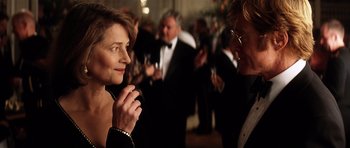 Movie still from “Spy Game” (2001), directed by Tony Scott – A woman in a black dress is talking to a man in a black suit; Close Up shot, Over the shoulder angle