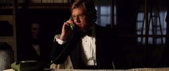Movie still from “Spy Game” (2001), directed by Tony Scott – A man in a tuxedo talking on a phone; Medium shot, Low angle