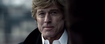 Movie still from “Spy Game” (2001), directed by Tony Scott – A person wearing a suit and tie; Close Up shot, Over the shoulder angle