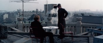 Movie still from “Spy Game” (2001), directed by Tony Scott – Two men sitting at a table on top of a building; Wide shot, Over the shoulder angle