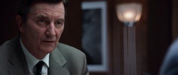 Movie still from “Spy Game” (2001), directed by Tony Scott – A person wearing a suit and tie; Close Up shot, Over the shoulder angle