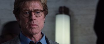 Movie still from “Spy Game” (2001), directed by Tony Scott – A person wearing glasses and a jacket; Close Up shot, Low angle