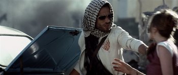 Movie still from “Spy Game” (2001), directed by Tony Scott – A man wearing a head scarf while riding a motorcycle; Medium shot, Over the shoulder angle